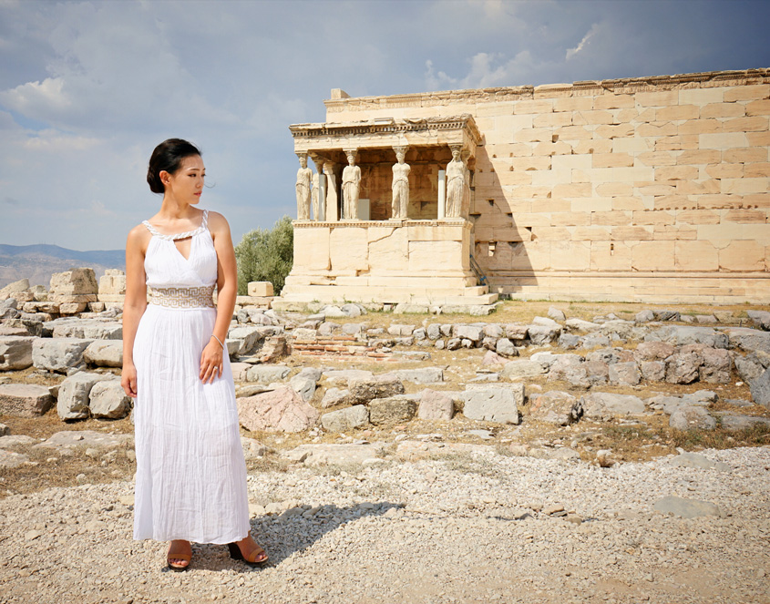 the eleusinian mysteries - a woman stands in front of a greek structure - supernatural chronicles