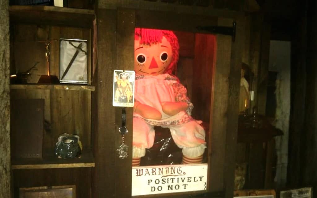 Annabelle haunted doll in wooden and glass case during NESPR tour linked to paranormal investigator Dan Rivera death